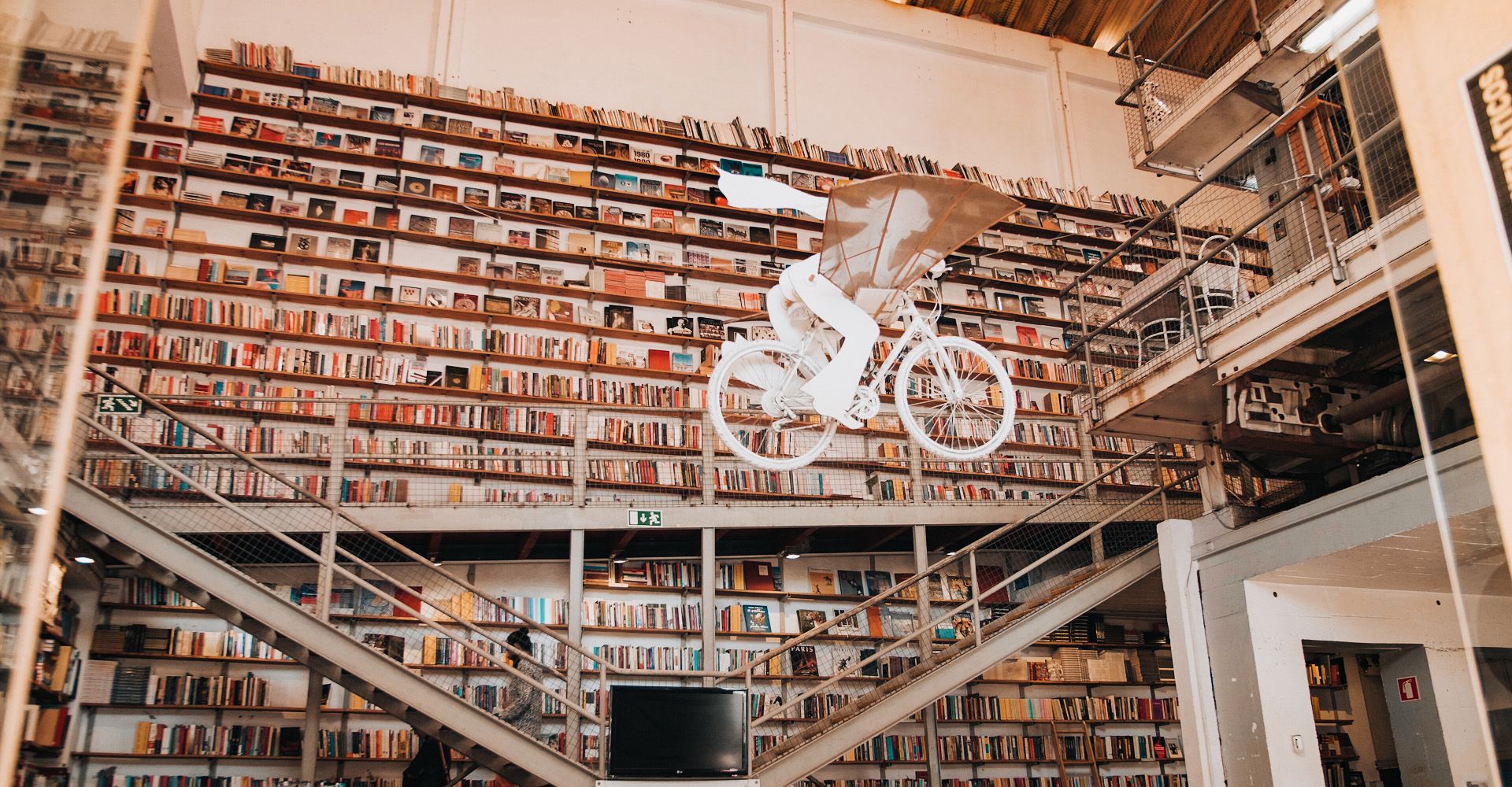 A library Ler Devagar with a bicycle hanging from the ceiling. Lx Factory, Alcântara, Lisbon.