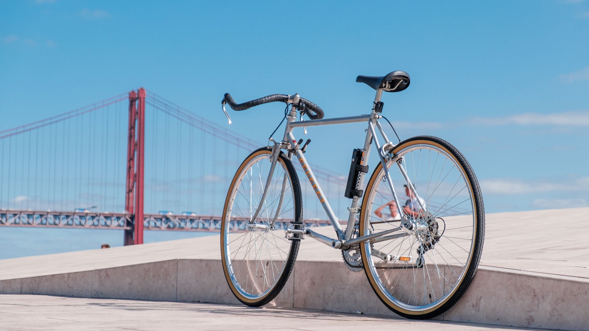 A bicycle is parked on the top of MAAT in front of a Bridge April 25Th