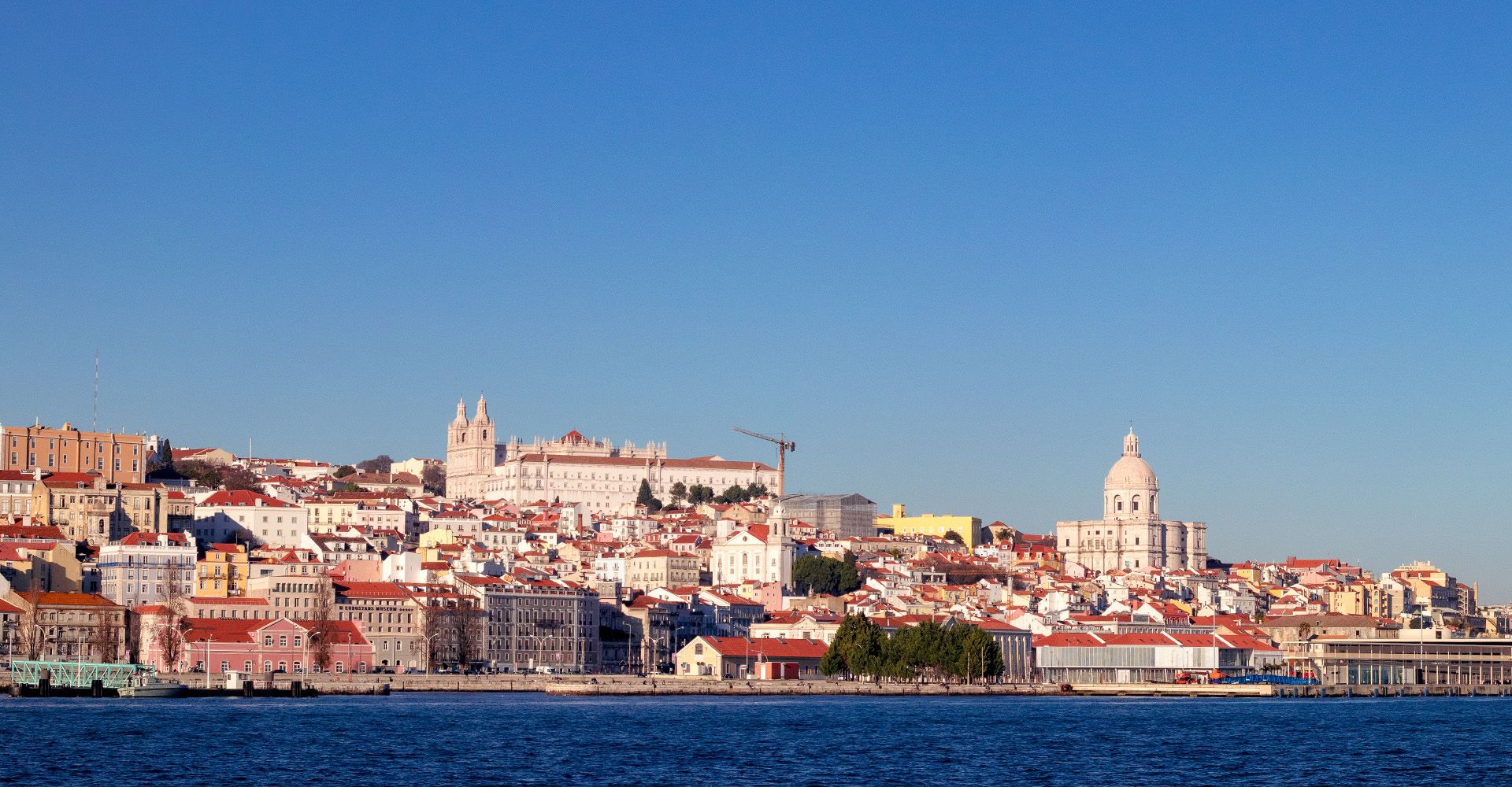 A Lisbon skyline with Tejo River in the foreground.